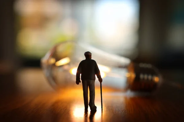 高齢者の思考の概念イメージ 電球を見てシニア男 — ストック写真