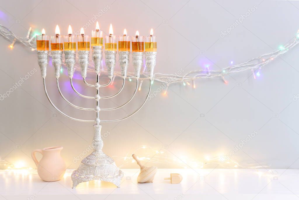 Religion image of jewish holiday Hanukkah background with menorah (traditional candelabra) and spinning top toy