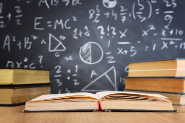 Okul kitapları formüllü karatahtanın önünde. eğitim kavramı