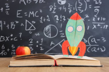 Okul kitapları formüllü karatahtanın önünde. eğitim kavramı