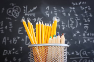Tahtanın önünde formüllü kalemler. eğitim kavramı