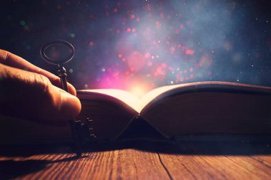 Eski anahtarlı ahşap masadaki açık antika kitap görüntüsü