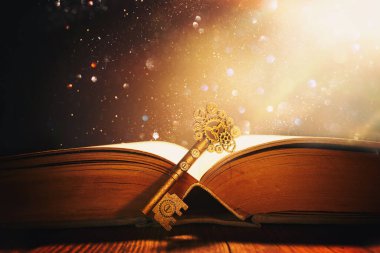 Eski anahtarlı ahşap masadaki açık antika kitap görüntüsü