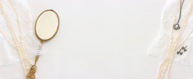 Beyaz, narin dantel kumaş, inciler ve klasik el aynasının arka planı.