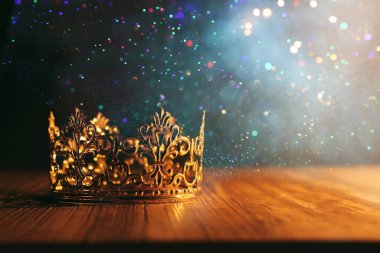 Tahta masanın üzerindeki güzel kraliçe ve kral tacının gösterişsiz görüntüsü. Eski model filtrelenmiş. fantezi ortaçağ dönemi