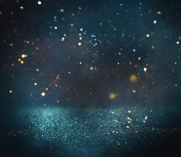 background of abstract glitter lights. gold, blue and black. de focused