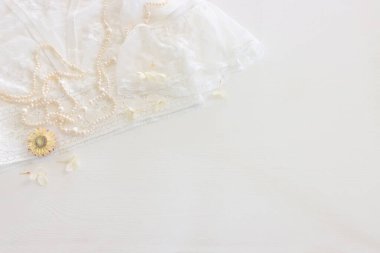 Beyaz, narin dantel kumaş, kuru çiçekler ve incilerin arka planı