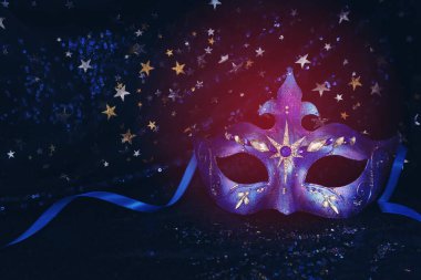 Mavi siyah yıldızların arka planında zarif ve narin Venedik maskesinin fotoğrafı