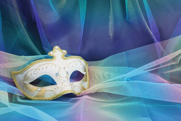 青のシフォンの背景にエレガントで繊細なヴェネツィアのマスクの写真 — ストック写真