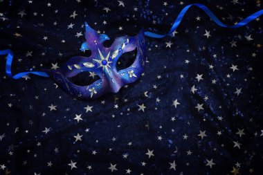 Mavi siyah yıldızların arka planında zarif ve narin Venedik maskesinin fotoğrafı