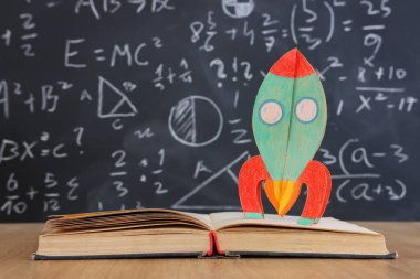 Okul kitapları formüllü karatahtanın önünde. eğitim kavramı