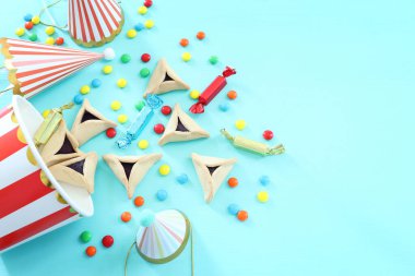 Purim bayramı konsepti (Yahudi karnavalı bayramı). Ahşap masanın üzerinde Hamantaschen kurabiyeleri