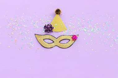 Mardi Gras 'nın maskeli pulların mor arkaplandaki resmi. Yukarıdan görünüm