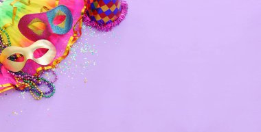 Mor arka planda Mardi Gras maskesi tatili görüntüsü. Yukarıdan görünüm