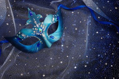Mavi siyah yıldızların arka planında zarif ve narin Venedik maskesinin fotoğrafı