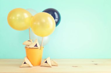 Purim bayramı konsepti (Yahudi karnavalı bayramı). Ahşap masanın üzerinde Hamantaschen kurabiyeleri