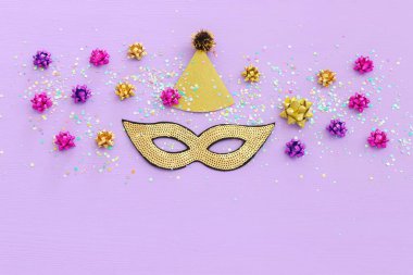 Mardi Gras 'nın maskeli pulların mor arkaplandaki resmi. Yukarıdan görünüm