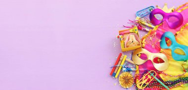Purim kutlaması konsepti (Musevi karnaval bayramı) mor ahşap arka plan üzerine