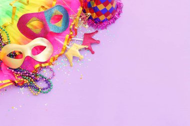 Mor arka planda Mardi Gras maskesi tatili görüntüsü. Yukarıdan görünüm
