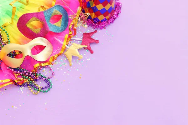 Mor arka planda Mardi Gras maskesi tatili görüntüsü. Yukarıdan görünüm