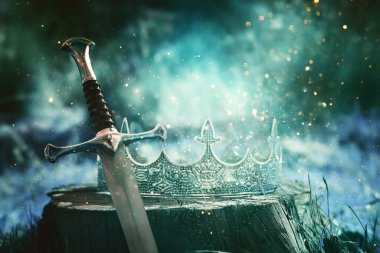 İngiltere ormanlarındaki altın kral tacının ve kılıcın gizemli ve sihirli fotoğrafı. Ortaçağ konsepti.