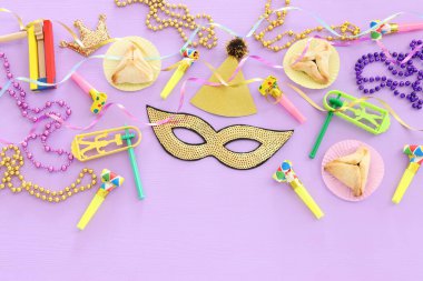 Purim kutlaması konsepti (Musevi karnaval bayramı) mor ahşap arka plan üzerine