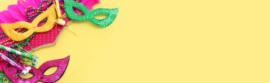 Sarı arka planda Mardi Gras ve Brezilya karnaval maskesi tatili görüntüsü. Yukarıdan görünüm