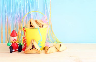 Purim bayramı konsepti (Yahudi karnavalı bayramı). Ahşap masanın üzerinde Hamantaschen kurabiyeleri