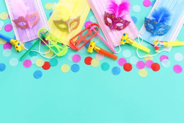 Maskeli balo maskesi arkaplanının en üst görünümü. Düz yatıyordu. Purim kutlaması (Yahudi karnavalı bayramı). Coronavirus önleme konsepti, tıbbi maske