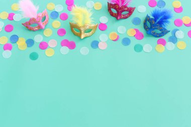 Yeşil arka planda renkli maskelerin bayram görüntüsü. Yukarıdan görünüm