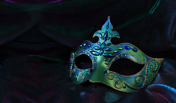 Фото элегантной и нежной венецианской маски на тёмном фоне