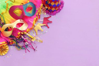 Mor arka planda Mardi Gras maskesi tatili görüntüsü. Yukarıdan görünüm