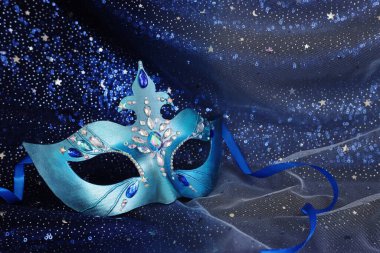 Mavi siyah yıldızların arka planında zarif ve narin Venedik maskesinin fotoğrafı