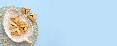 Purim bayramı konsepti (Yahudi karnavalı bayramı). Mavi pastel arka planda Hamantaschen kurabiyeleri