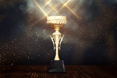 Koyu arkaplan üzerine parlak örtülü altın bir kupa görüntüsü