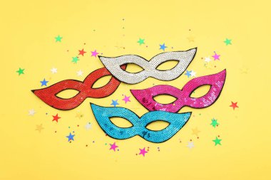 Karnaval partisinin resmi sarı arka planda maskeler. Yukarıdan görünüm