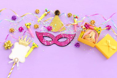 Purim kutlaması konsepti (Musevi karnaval bayramı) mor ahşap arka plan üzerine