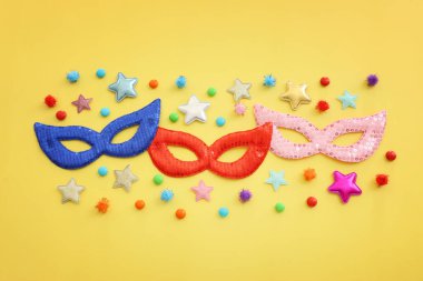 Karnaval partisinin resmi sarı arka planda maskeler. Yukarıdan görünüm