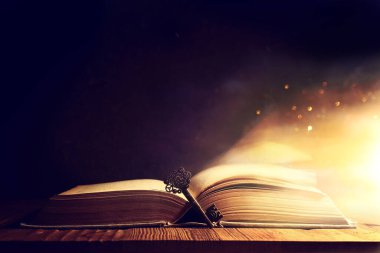 Eski anahtarlı ahşap masadaki açık antika kitap görüntüsü