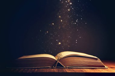 Eski anahtarlı ahşap masadaki açık antika kitap görüntüsü