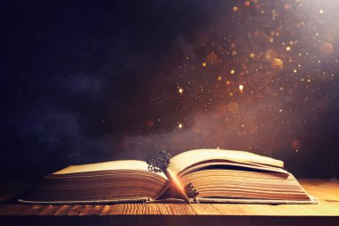 Eski anahtarlı ahşap masadaki açık antika kitap görüntüsü