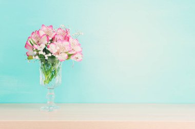 Tahta masanın üzerinde pembe çiçekler ve nane arkaplanı.