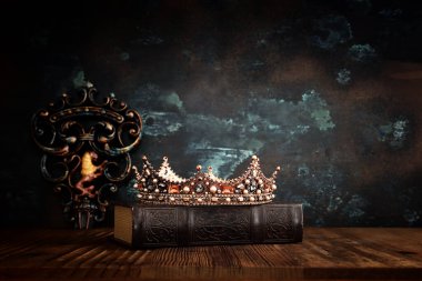 Güzel bir kraliçe ya da kral tacının ve eski bir kitabın gösterişsiz görüntüsü. fantezi ortaçağ dönemi