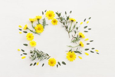 Sarı kasımpatı tarlası çiçeklerinin ahşap beyaz arka plandaki üst görüntüsü. Düz yatıyordu