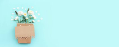 Beyaz çiçeklerin üst görünümü bileşimi ve mavi pastel arkaplan üzerine boş nota