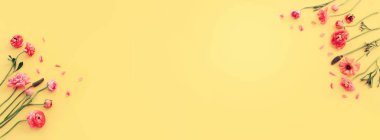 Sarı arkaplan üzerindeki pembe çiçeklerin üst görünümü