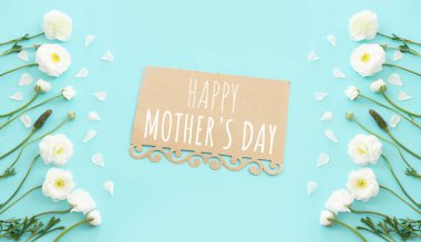 Mavi pastel arka planda beyaz çiçeklerle anneler günü konsepti