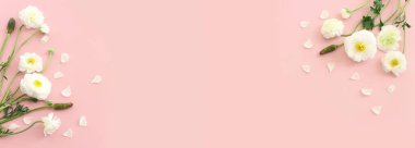 Pembe pastel arka planda beyaz çiçeklerin üst görünümü