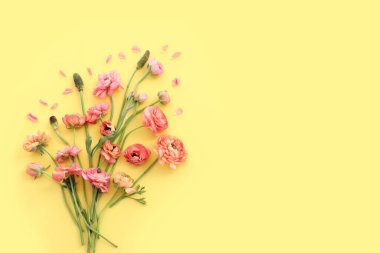 Sarı arkaplan üzerindeki pembe çiçeklerin üst görünümü