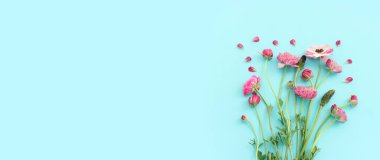 Mavi arkaplanda pembe çiçeklerin üst görünümü
